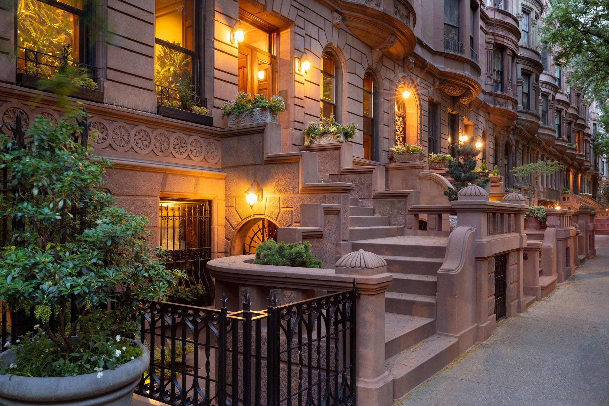 Twilight brownstone townhouse with golden lighting